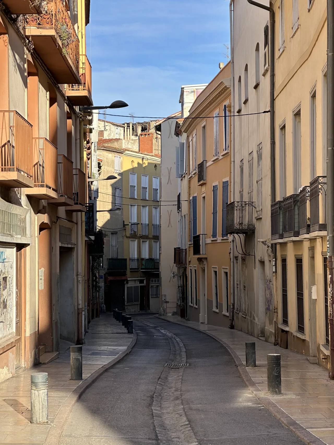 Narrow street with historic buildings in the city of Perpignan, Occitania, France, January